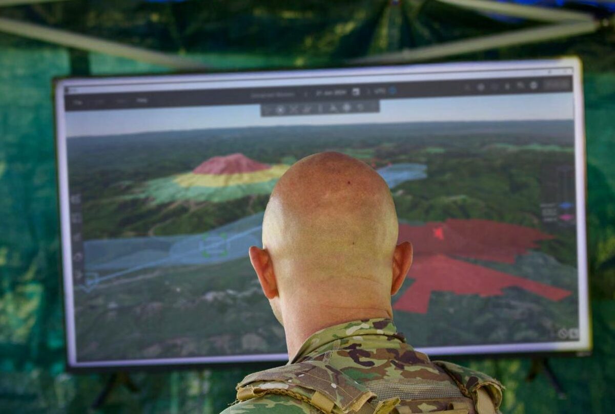 Operator reviewing an Eris 3D mission view with a route corridor and threat areas on a large display